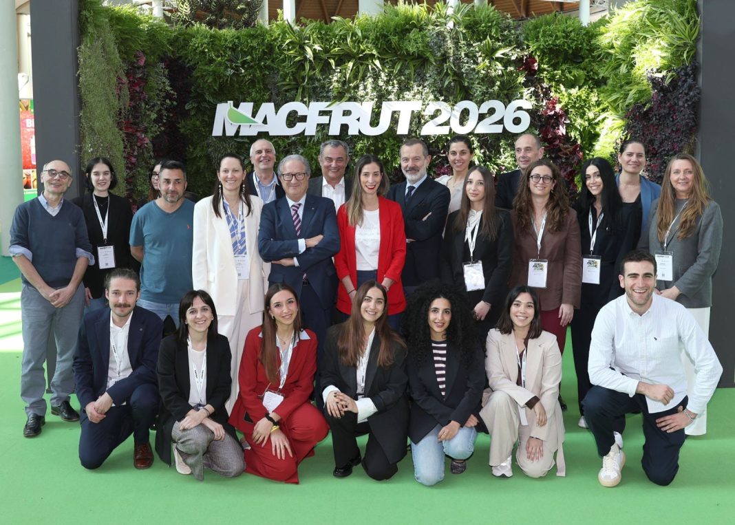 Group of professionals posing for a photo at Macfrut 2026 in front of a lush green plant wall with the event logo.