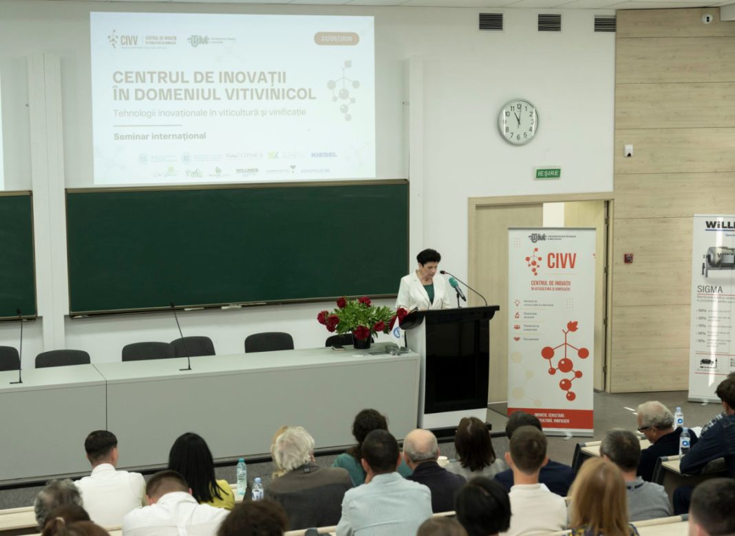 Speaker at a podium presenting to a lecture hall audience; projection screen shows a seminar on viticulture innovations (Romanian text visible).