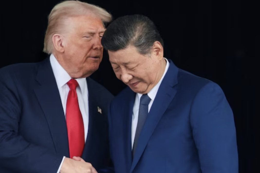 Two men in dark suits shake hands while leaning their heads together in a formal diplomatic moment.
